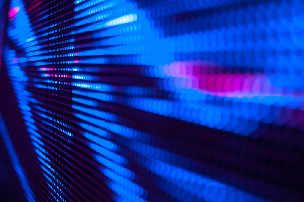 Close-up of a colorful LED display showing bright, vibrant blue and pink lights in an abstract pattern.